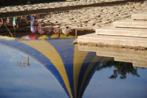 Reflexo da tenda da tenda da Flipinha em poça no centro de Paraty – Flip